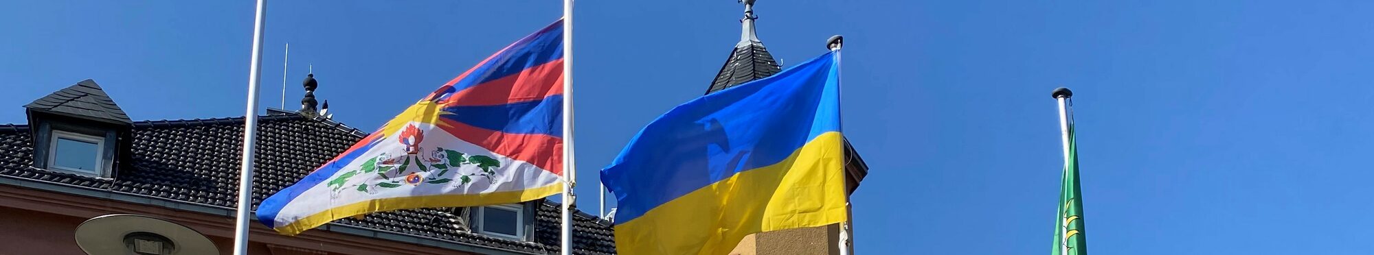 Das Rathaus Vettweiß mit den Flaggen der Ukraine und Tibets