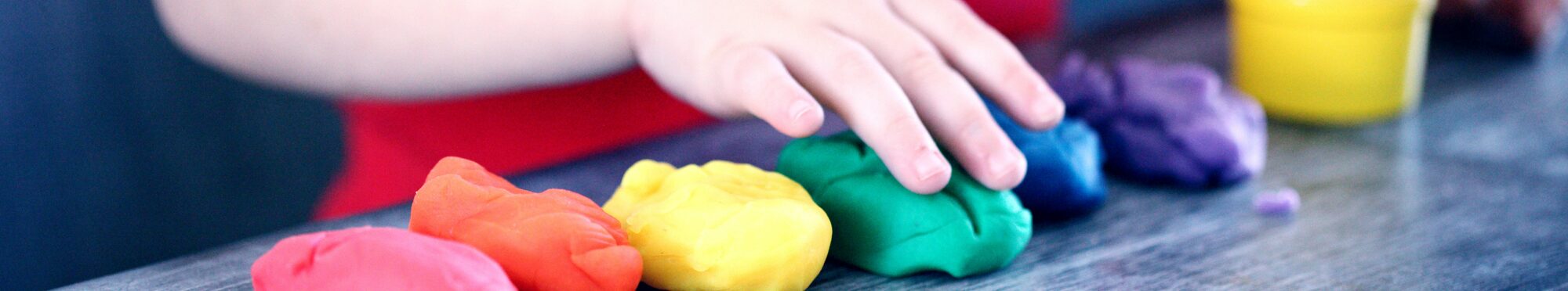 Kinderhände spielen mit Knetgummi